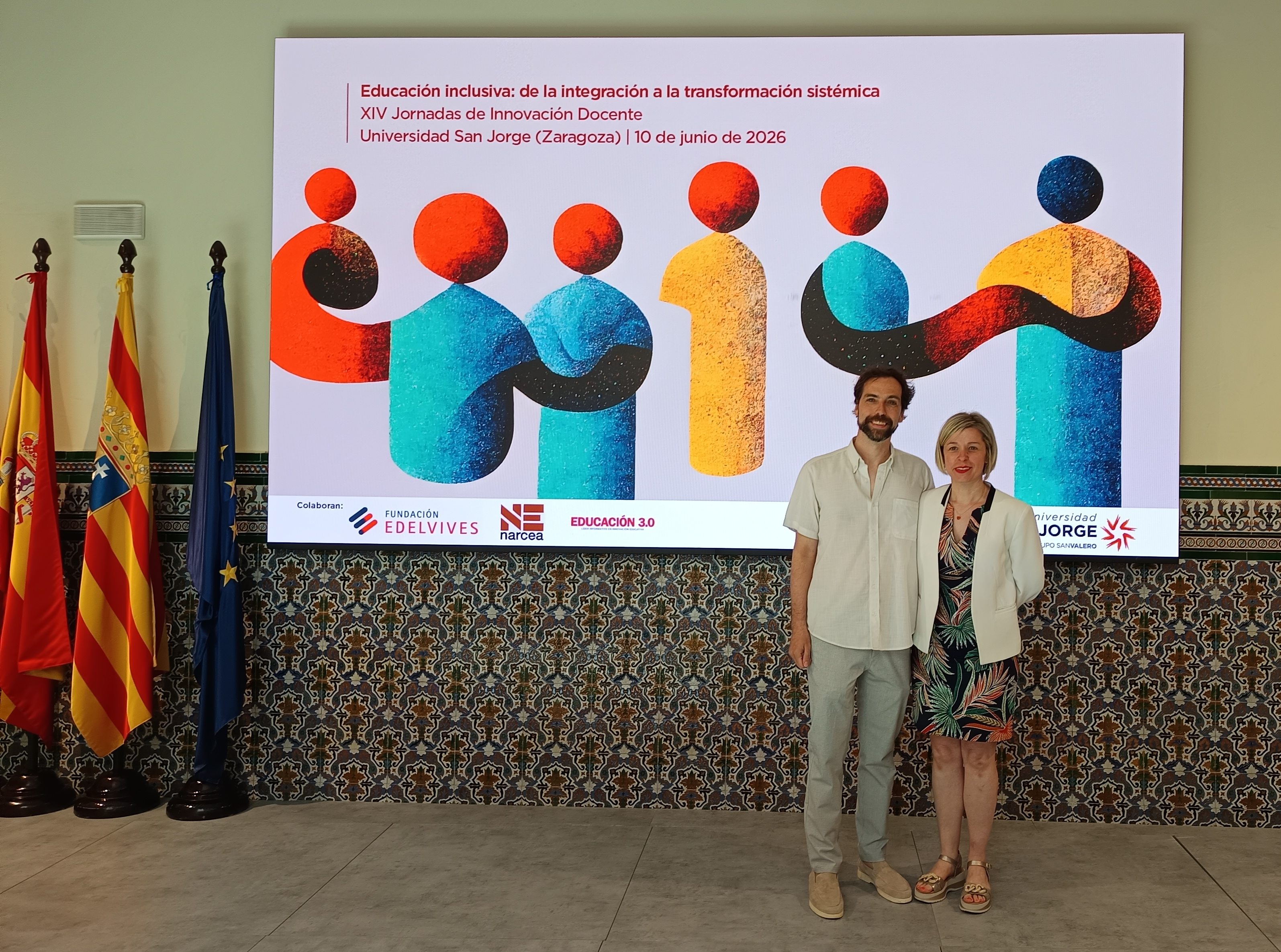 Imagen Ana y Juan Andrés junto al cartel de las Jornadas